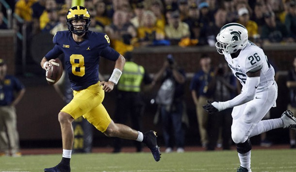 Oct 7, 2017; Ann Arbor, MI, USA; Michigan Wolverines quarterback John O'Korn (8) scrambles away from Michigan State Spartans defensive end Brandon Randle (26) in the first half at Michigan Stadium. Photo Credit: Rick Osentoski-USA TODAY Sports
