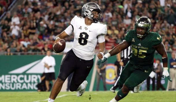 Nov 23, 2018; Tampa, FL, USA; UCF Knights quarterback Darriel Mack Jr. (8) runs out of the pocket as South Florida Bulls defensive tackle Brandon Boyce (95) pressures during the second half at Raymond James Stadium. Photo Credit: Kim Klement-USA TODAY Sports