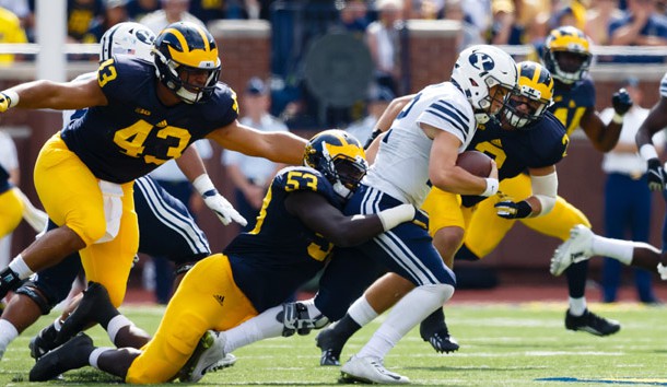 Sep 26, 2015; Ann Arbor, MI, USA; Brigham Young Cougars quarterback Tanner Mangum (12) is tackled by Michigan Wolverines defensive end Mario Ojemudia (53) in the third quarter at Michigan Stadium. Michigan won 31-0. Mandatory Credit: Rick Osentoski-USA TODAY Sports