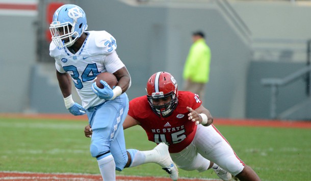 Nov 28, 2015; Raleigh, NC, USA; North Carolina Tar Heels running back Elijah Hood (34) runs the ball as North Carolina State Wolfpack defensive end Darian Roseboro (45) defends during the first half at Carter Finley Stadium. Mandatory Credit: Rob Kinnan-USA TODAY Sports