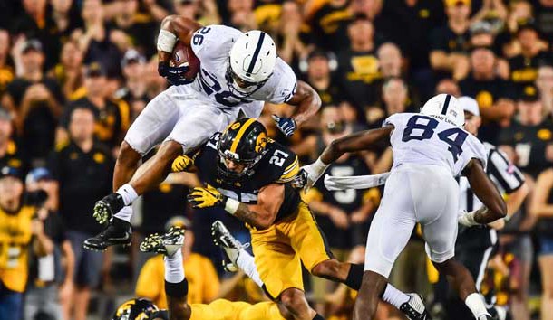 Sep 23, 2017; Iowa City, IA, USA; Penn State Nittany Lions running back Saquon Barkley (26) jumps over Iowa Hawkeyes defensive back Joshua Jackson (15) and defensive back Amani Hooker (27) as Nittany Lions wide receiver Juwan Johnson (84) looks to block during the fourth quarter at Kinnick Stadium. Penn State won 21-19. Photo Credit: Jeffrey Becker-USA TODAY Sports