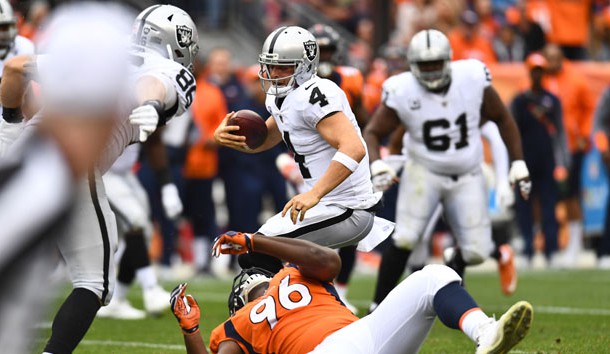Oct 1, 2017; Denver, CO, USA; Oakland Raiders quarterback Derek Carr (4) is injured on this play as Denver Broncos defensive end Shelby Harris (96) falls backwards in the second half at Sports Authority Field at Mile High. Photo Credit: Ron Chenoy-USA TODAY Sports
