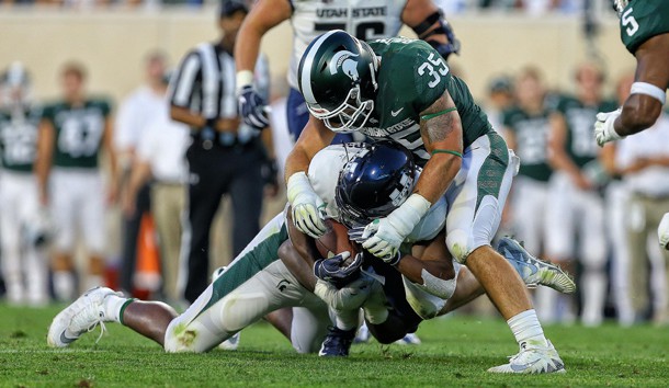 Aug 31, 2018; East Lansing, MI, USA; Utah State Aggies running back Darwin Thompson (5) is tackled by Michigan State Spartans linebacker Joe Bachie (35) during the first quarter of a game at Spartan Stadium. Photo Credit: Mike Carter-USA TODAY Sports