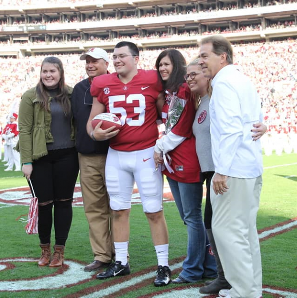 Ryan Parris and his family with Nick Saban being recognized on Senior Day on the field before the Auburn game. 