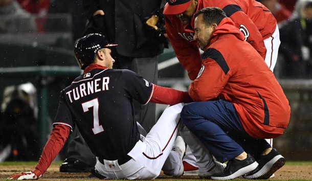 Apr 2, 2019; Washington, DC, USA; Washington Nationals shortstop Trea Turner (7) is tended to by the trainer and manager Dave Martinez (4) after injuring his finger against the Philadelphia Phillies during the first inning at Nationals Park. Mandatory Credit: Brad Mills-USA TODAY Sports